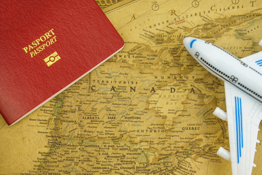 Close,Up,On,Canada,Map,With,Passport,And,Toy,Aircraft.